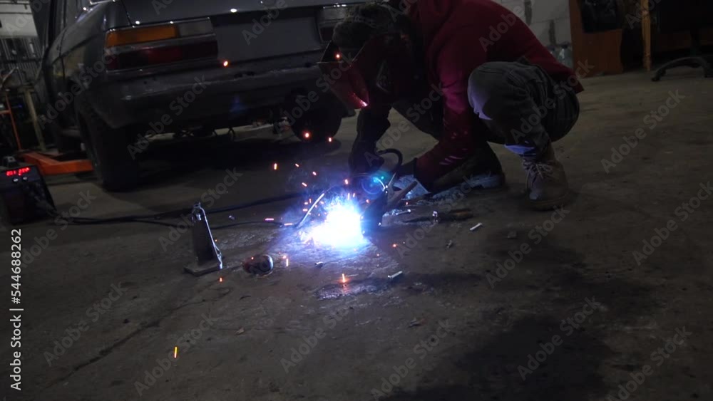 the welder performs welding works of metal structures for custom cars the welder performs welding works of metal structures for custom cars