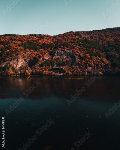 Fototapeta Naklejka Na Ścianę i Meble -  Drone landscape of a lake and forest on the hill with blue sky.