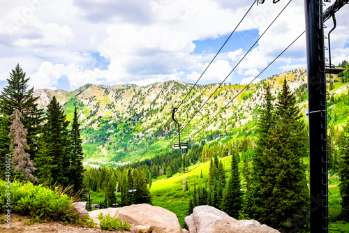Albion Basin, Utah summer landscape with ski lift chairs on cables and cloudy clouds blue sky in rocky Wasatch mountains on hiking trail photo
