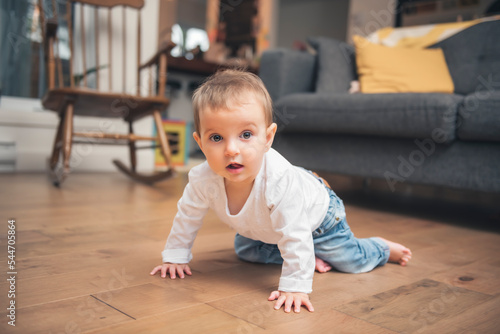 baby 9 months old learns to crawl at home. baby crawling on the floor