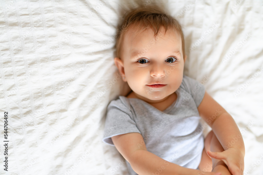 Portrait of cute little baby on beedsheets at home. Portrait of cute little baby on beedsheets at home.