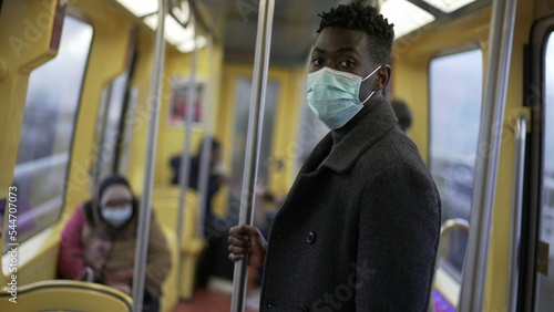 African man standing in subway metro wearing coronavirus mask underground commute5