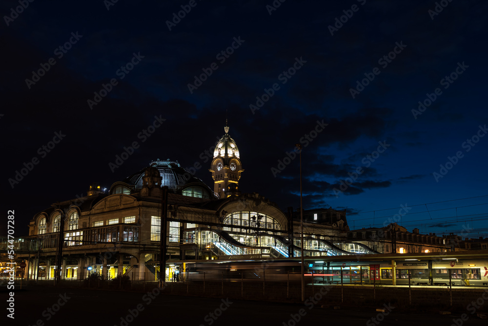 Illuminated Benedictins Train Station of Limoges City, by night, with a train arriving