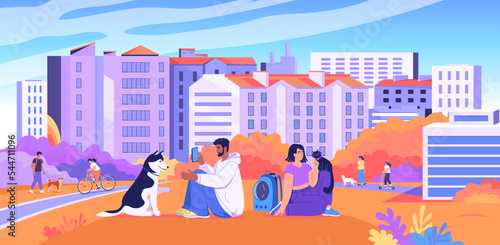 Young people are having a great time resting in the autumn city park with their dogs and cats
