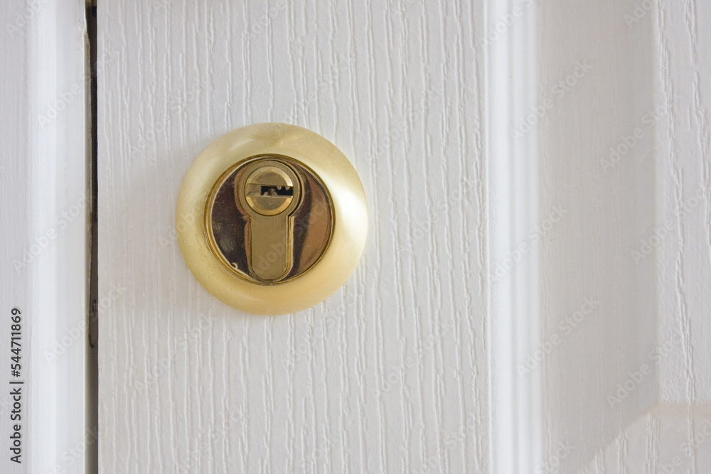 Golden door lock on the white door close up Golden door lock on the white door close up
