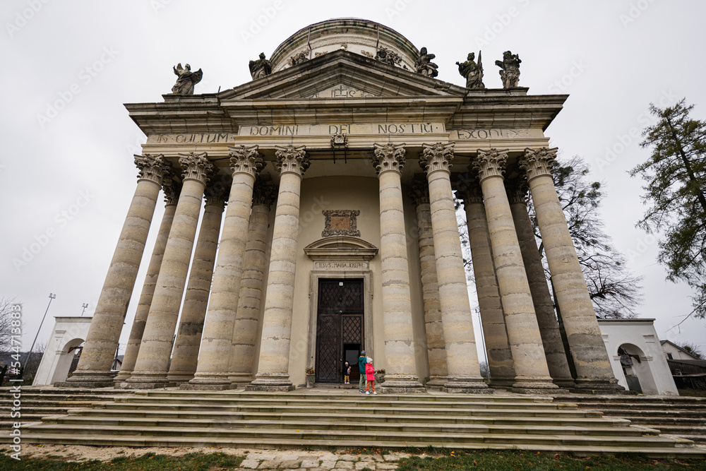 Obraz premium Children against baroque roman cattholic church in Pidhirtsi, Lviv Oblast, Ukraine.
