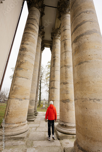 Boy against columns of baroque roman cattholic church in Pidhirtsi, Lviv Oblast, Ukraine.