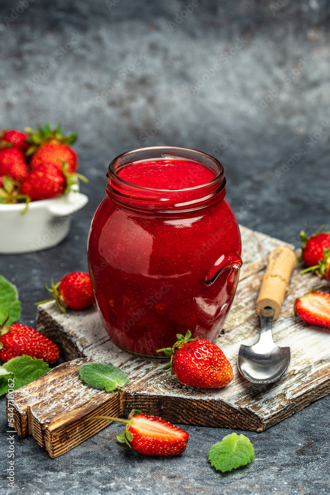 A jar of strawberry jam on a wooden board, vertical image. top view. place for text A jar of strawberry jam on a wooden board, vertical image. top view. place for text