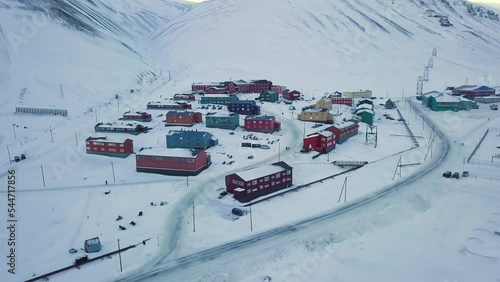 Aerial view of Longyearbyen, Svalbard in winter. With colorful houses, snow-capped mountains, with avalanche protection and fjord. Drone flight. High quality 4k footage