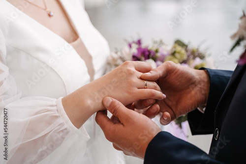 the groom puts on the ring to the bride, close-up exchange of rings