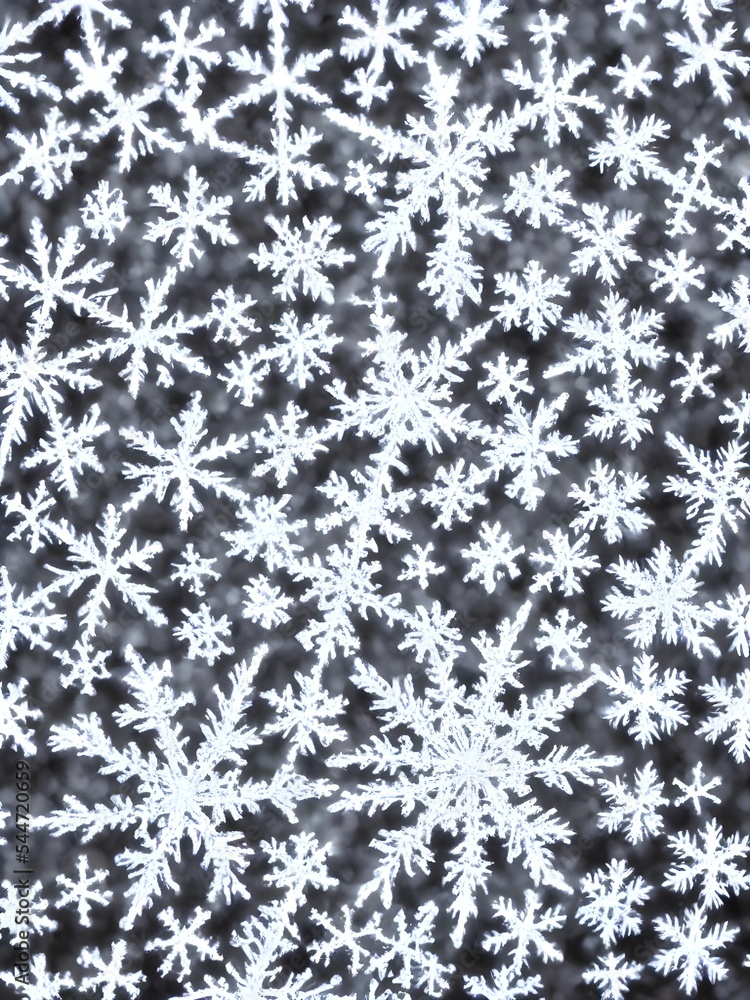 Fototapeta premium The photo is of a delicate snowflake, suspended in midair. It's well-defined edges are shining brightly against the dark background. The center of the flake looks like it has been cut out, revealing i