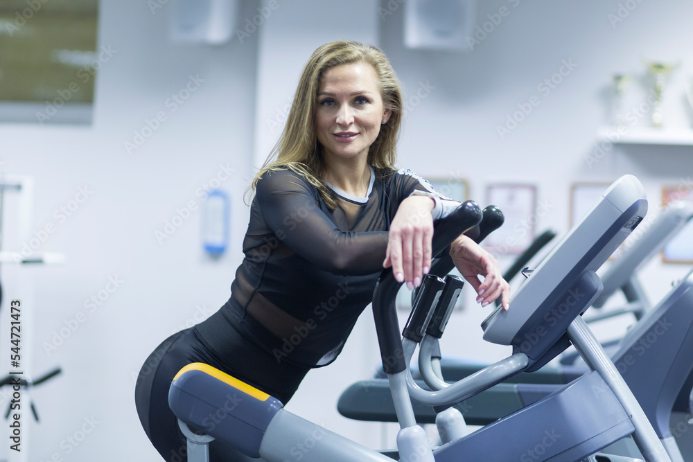 Fototapeta premium Beautiful woman in the gym. Exercise in the fitness room.
