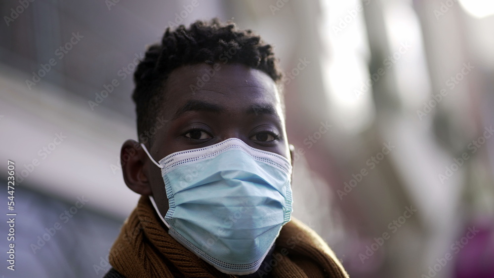 Black African man wearing covid-19 face mask standing outside in street looking at camera2