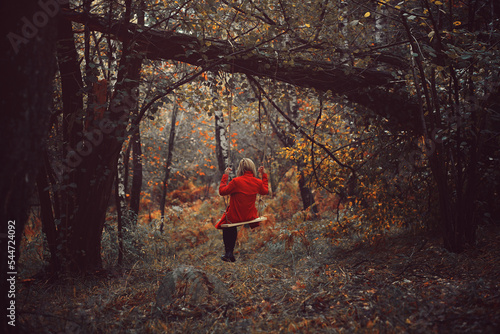 Woman with red coat on a swing photo