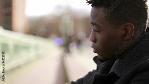 Anxious young black man suffering emotional pain sitting on sidewalk in street2 photo