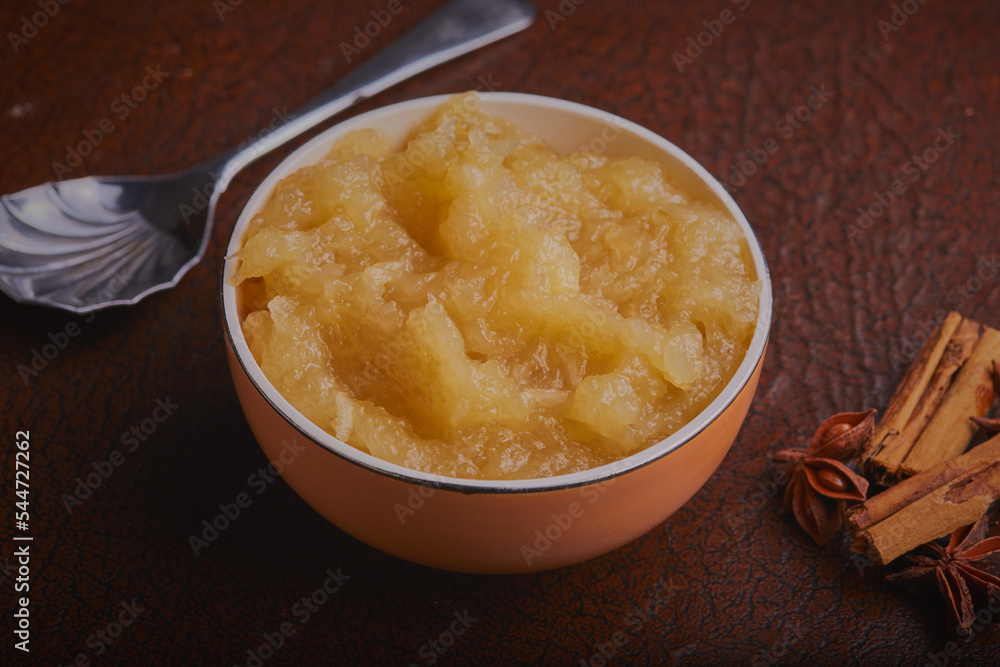 Dish of freshly made apple sauce on a textured background.