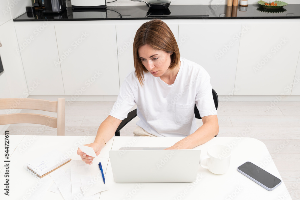 Close up of shocked woman sitting at the table, stressed and confused by calculate expense from invoice or bills, have no money to pay mortgage or loan. High prices and spending money concept