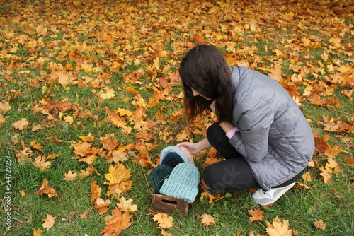 Hats crocheted knitted in the hands of a girlon the street. Product listing for sale. Urban style. Fashion. Autumn photo