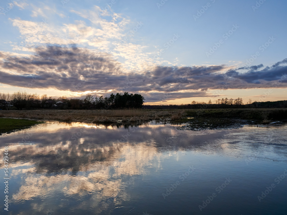 Fototapeta premium Autumn sunset tree reflection. Sunset sky over river trees. 