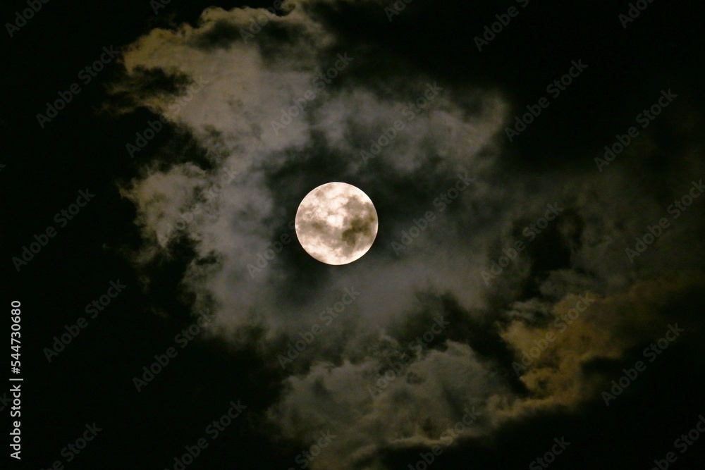A view of the full moon and clouds. Background image of the moon. A view of the full moon and clouds. Background image of the moon.