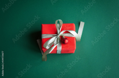 Banner with Christmas gift and decorations on green background.