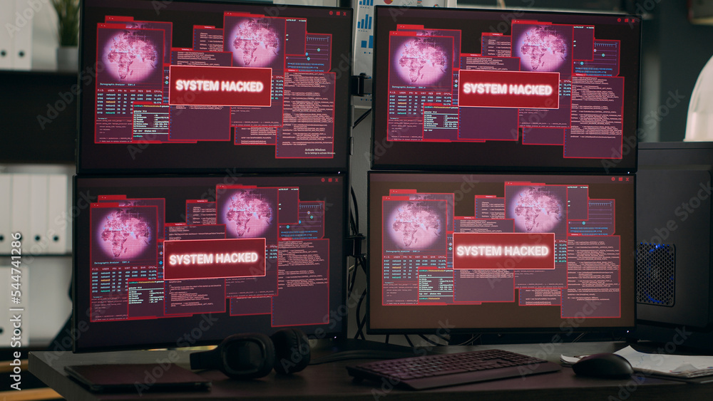 Multiple monitors displaying hacking warning alert after security