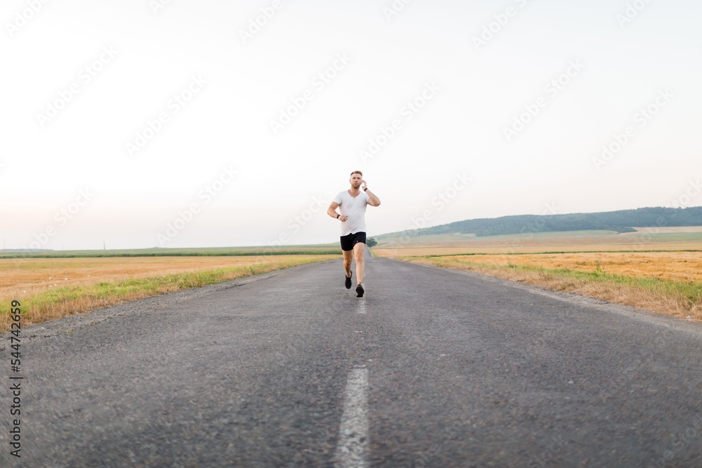 Obraz premium Man in earphones running outdoors