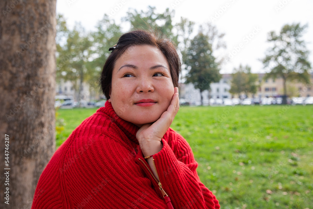 Outdoor portrait of a middle age chinese lady sitting at the public park