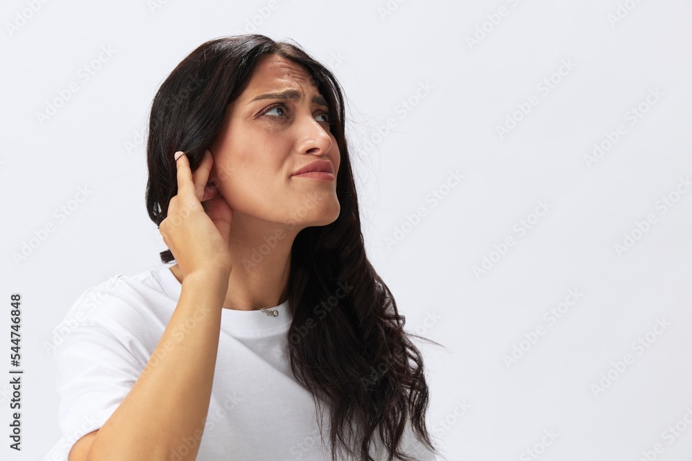 Woman toothache and sadness, inflammation of the teeth, a cold in a white t-shirt on a white background Woman toothache and sadness, inflammation of the teeth, a cold in a white t-shirt on a white background