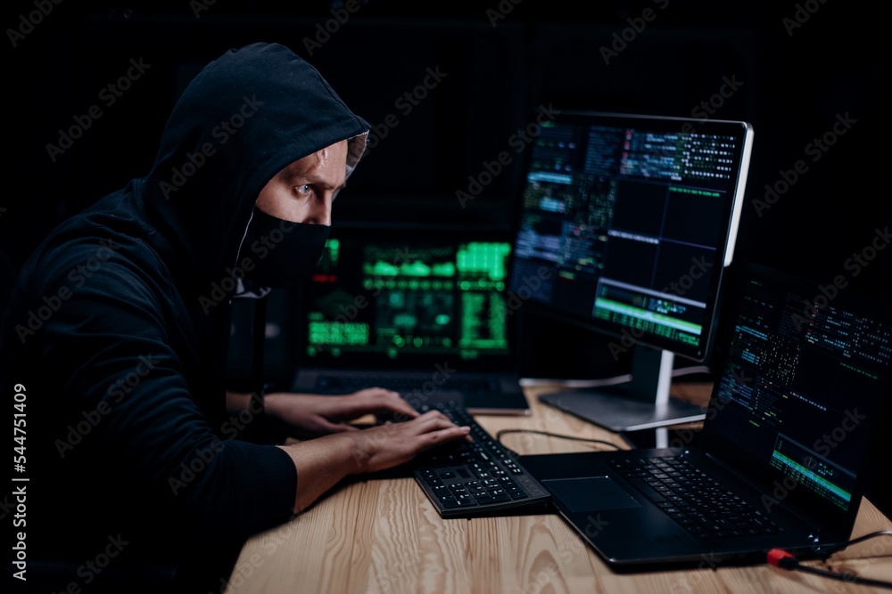 Hacker in mask coding on computer Hacker in mask coding on computer