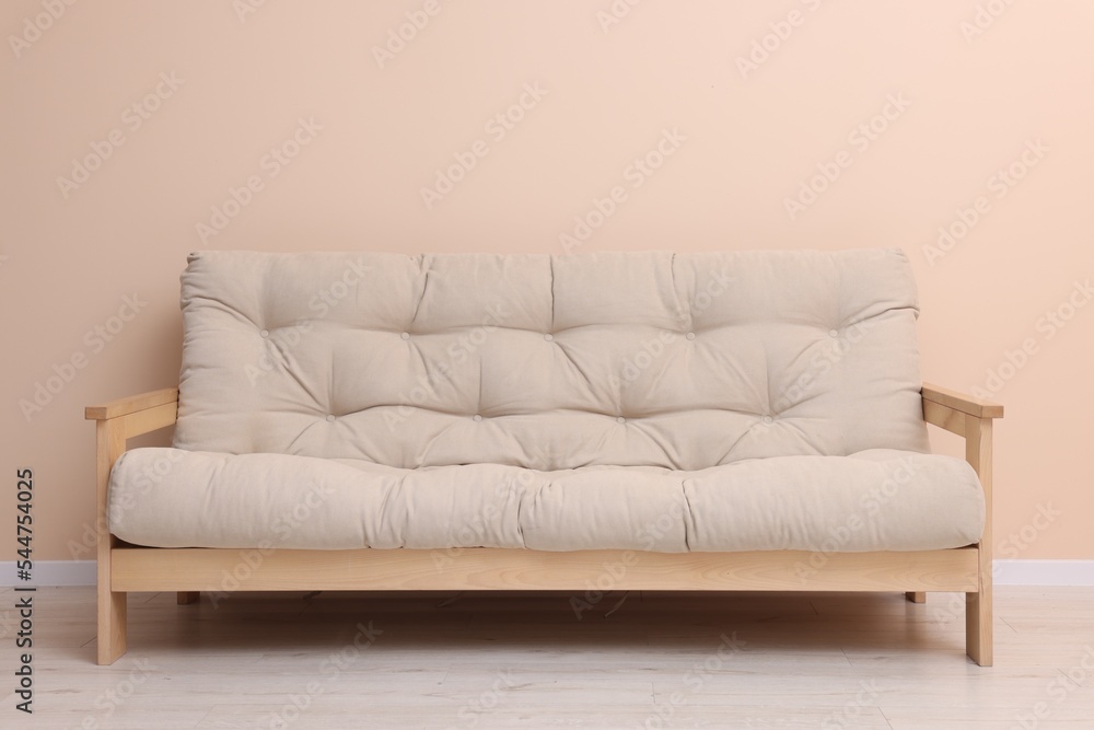 Comfortable sofa near beige wall on floor indoors