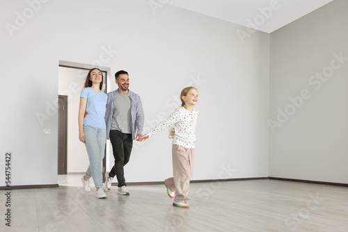 Happy family entering in their new apartment on moving day. Space for text