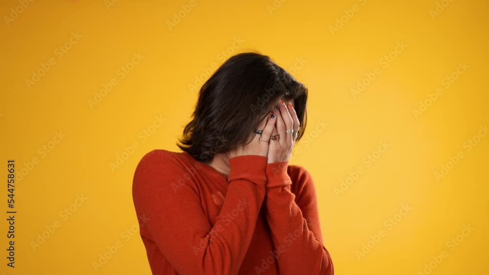 Shocked surprised portrait of angry, frustrated upset Hispanic Latino man covers eyes with hands isolated on solid yellow background. Shocked surprised portrait of angry, frustrated upset Hispanic Latino man covers eyes with hands isolated on solid yellow background.