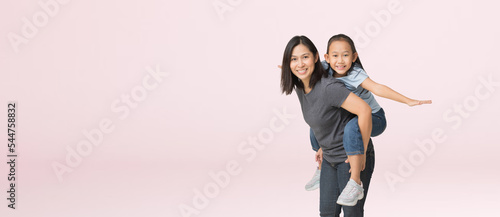 Happy asian family of mother and daughter hug spread out your arms, isolated on pink background with Clipping paths for design work empty free space