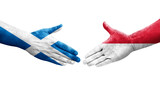 Handshake between Monaco and Scotland flags painted on hands, isolated transparent image.