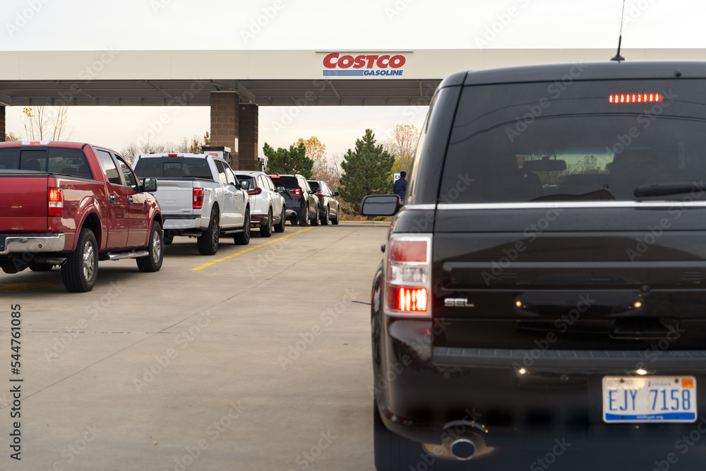 People in cars waiting in long lines to fill up vehicles with gas at
