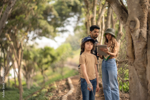 Family using a digital tablet while walking on a park