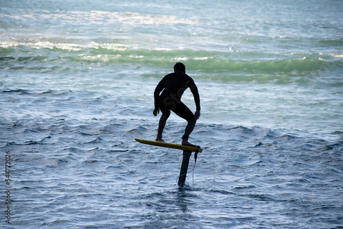 View of man riding foilboard (hydrofoil surfboard, foilsurfing)