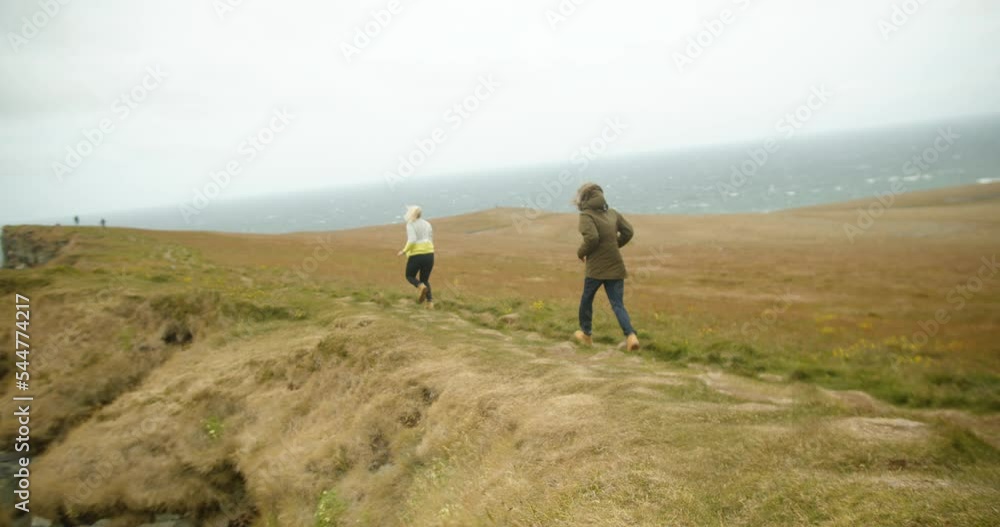 Happy Young Couple Travelers Running On Cliff Over Iceland Coast. - Slow Motion Happy Young Couple Travelers Running On Cliff Over Iceland Coast. - Slow Motion