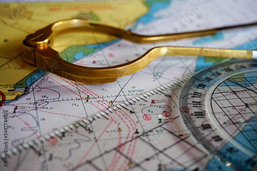 Compass course calculation, navigation, chart reading and sea chart orientation. Direction in north, east, south, west on meridians and parallels. Nautical chart and compass.