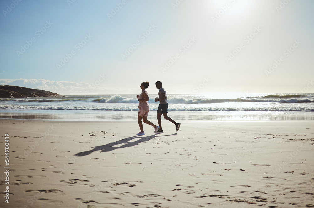 Exercise, couple and beach running at sunrise for health, training and wellness in nature against blue sky background. Fitness, family and woman with man on sand run along the sea, workout and cardio