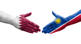 Handshake between Namibia and Qatar flags painted on hands, isolated transparent image.