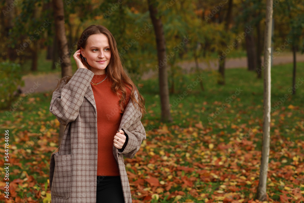 Beautiful young woman in jacket walking in autumn park Beautiful young woman in jacket walking in autumn park