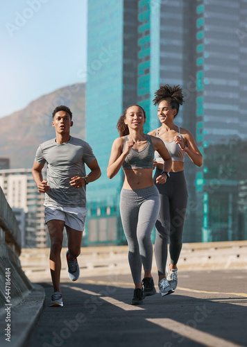 Diversity, fitness friends and running together in city for freedom or healthy lifestyle motivation. Runner athlete, sports training team and wellness coach outdoor workout for cardio exercise goal