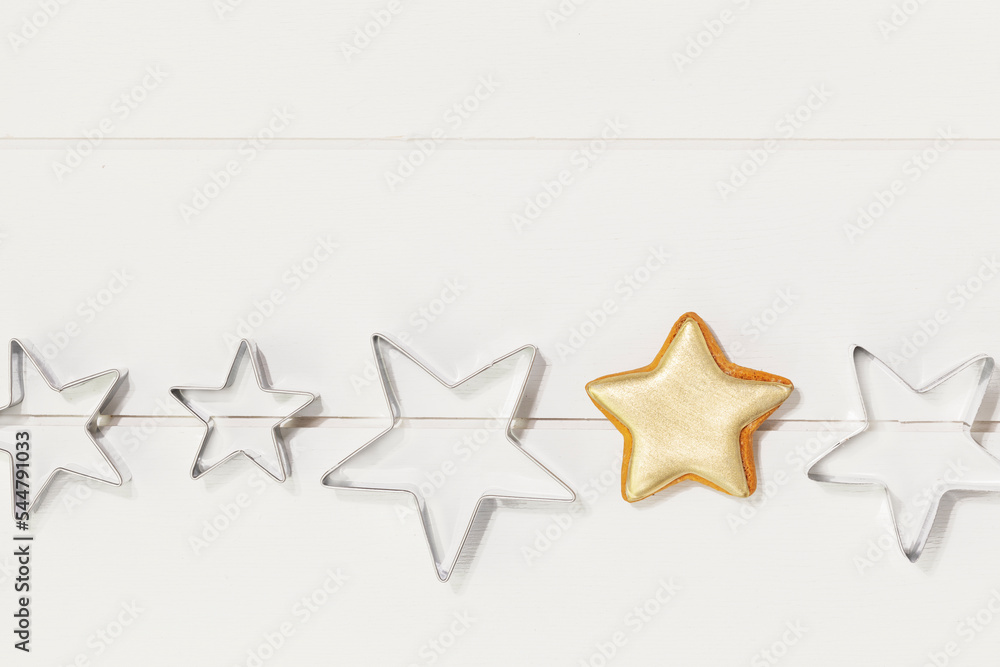 Cooking holiday cookies. Bakery flat lay. Ginger cookie in the form of stars, covered with gold glaze and cookie cutters on a white wooden background. Christmas and New Year Food Cooking holiday cookies. Bakery flat lay. Ginger cookie in the form of stars, covered with gold glaze and cookie cutters on a white wooden background. Christmas and New Year Food