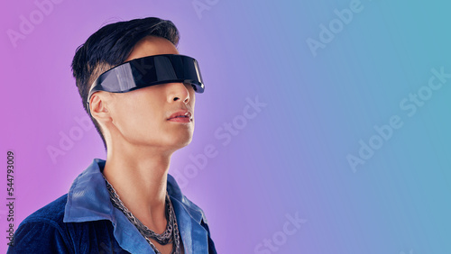 Beauty, fashion and man with cyberpunk glasses in studio with blue and purple background. Creative, cosmetics and young male model with visor for futuristic style, techno and designer clothing photo