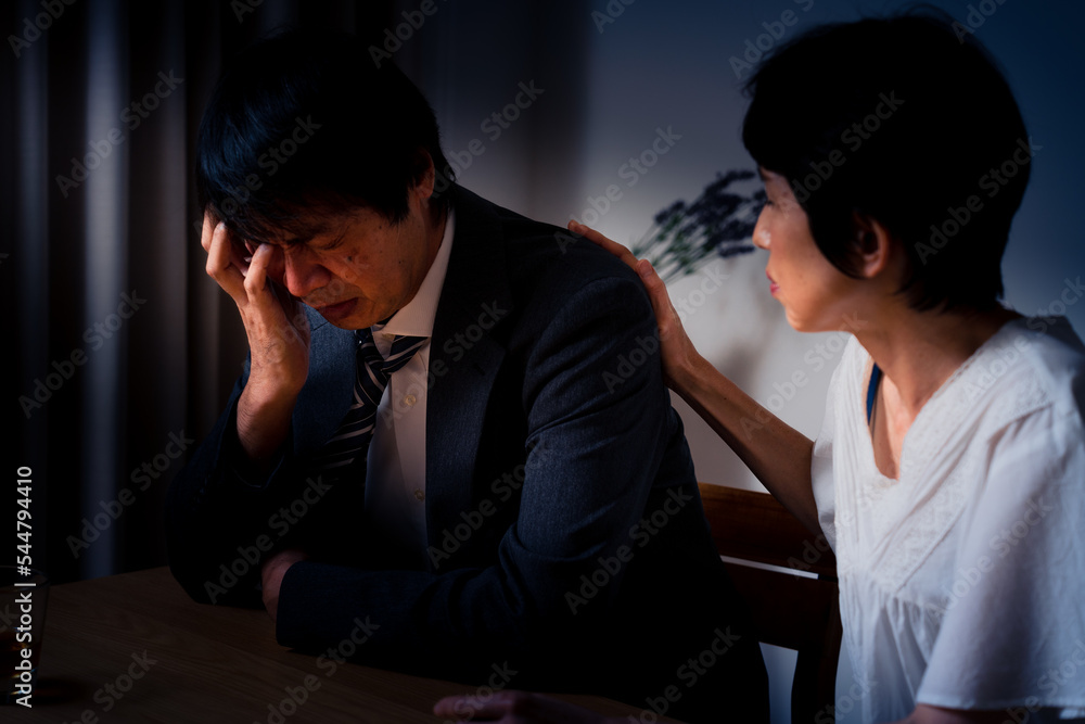 家でうなだれるミドル男性と彼を慰めるミドル女性 Stock Photo | Adobe Stock