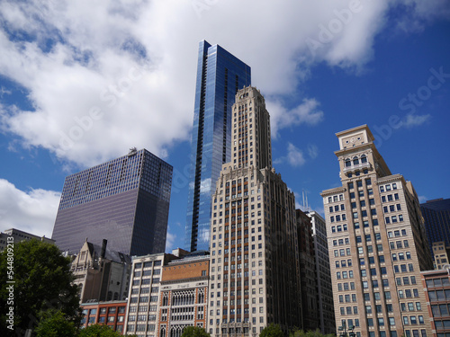 view from street level of skyscrapers in downtown Chicago on a sunny day with cloud backdrop © Daniel