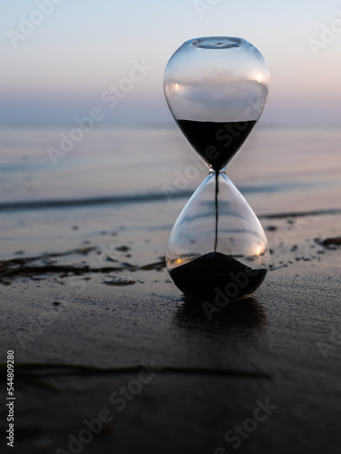 Sand hourglass at the beach at sunset