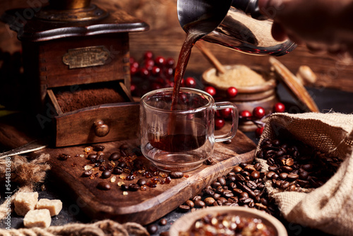 Foto Pouring coffee into a cup on a wooden vintage table